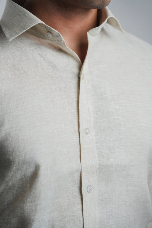 Close-up of a beige linen  button-up shirt on a neutral background