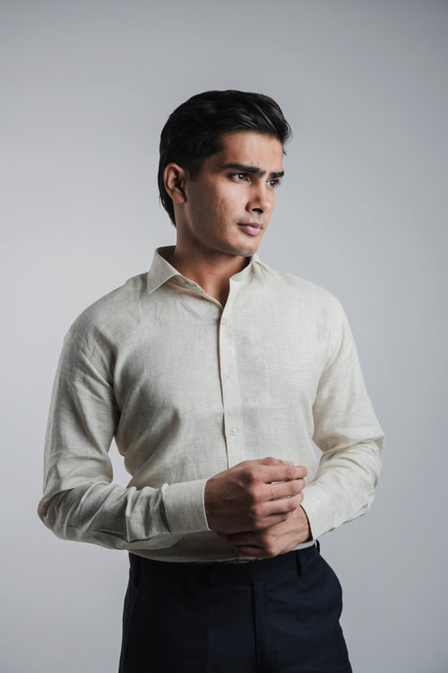 Man wearing a light-colored dress shirt against a plain background